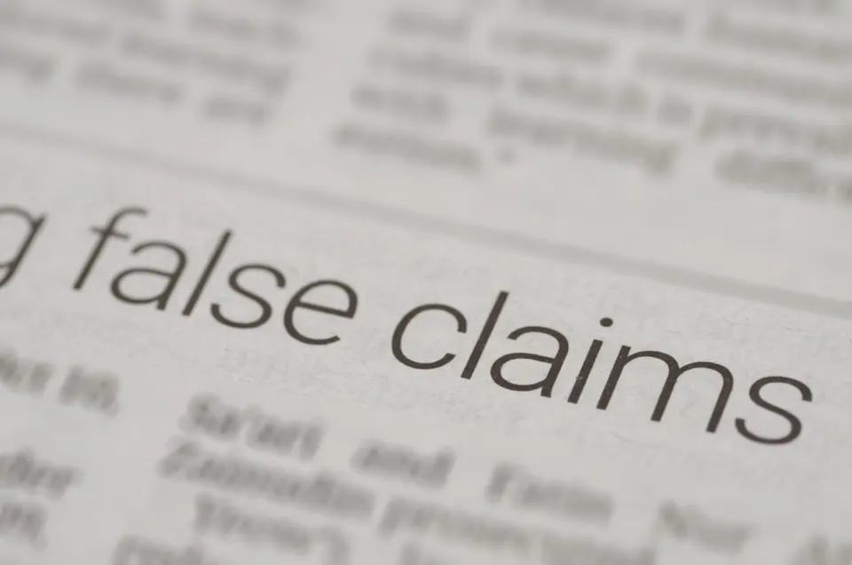 Next to a Newspaper Article Featuring 'False Statements' in Bold